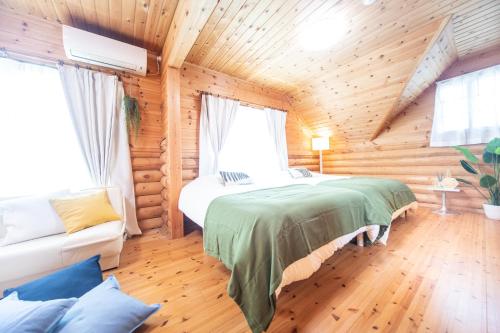 um quarto com uma cama num chalé de madeira em Awaji Large Log house in Goshiki em Sumoto