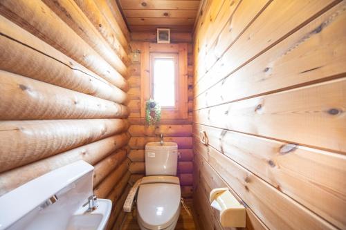 a wooden bathroom with a toilet and a window at Awaji Large Log house in Goshiki 2 in Sumoto