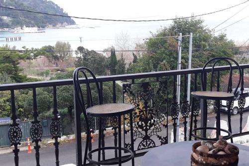 a balcony with two chairs and a table with a view at xara house in (( Filaréton ))