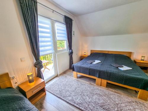 a bedroom with a bed and a large window at Aparthouse Bilic in Jajce
