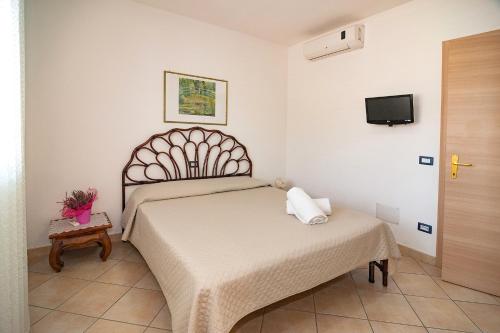 a bedroom with a bed and a table and a tv at Le Dune in San Teodoro