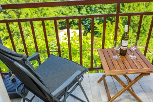 a table with two glasses and a bottle of wine at Aparthouse Bilic in Jajce