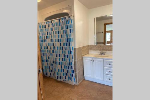 La salle de bains est pourvue d'une douche, d'un lavabo et d'un miroir. dans l'établissement Beautiful 2 Bedroom Apartment in Shediac Bridge, à Grande-Digue