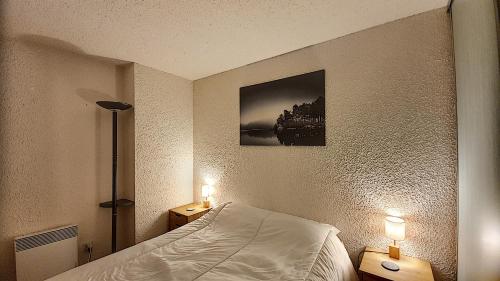 - une chambre avec un lit et deux lumières sur deux tables dans l'établissement APPARTEMENT 6 COUCHAGES - ST JEAN D'AULPS - PROCHE PIED DES PISTES - PROCHE MORZINE - Cimes 44, à Saint-Jean-dʼAulps
