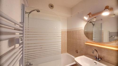 une salle de bain avec une douche, un lavabo et un miroir dans l'établissement APPARTEMENT 6 COUCHAGES - ST JEAN D'AULPS - PROCHE PIED DES PISTES - PROCHE MORZINE - Cimes 44, à Saint-Jean-dʼAulps