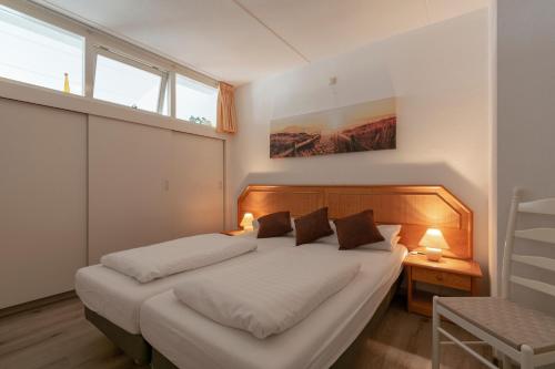 ein Schlafzimmer mit einem großen Bett mit zwei Kissen in der Unterkunft Strandslag appartement 223 - Julianadorp aan zee in Julianadorp