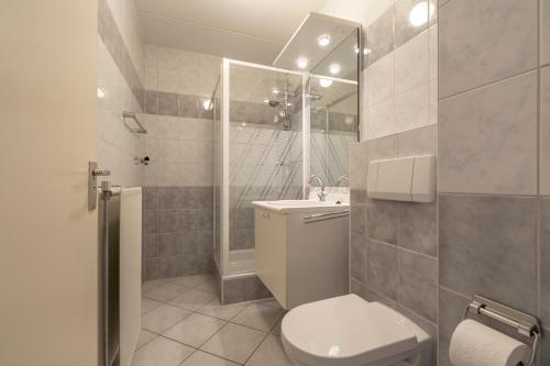 ein Bad mit einem WC, einem Waschbecken und einer Dusche in der Unterkunft Strandslag appartement 223 - Julianadorp aan zee in Julianadorp