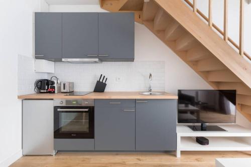 - une cuisine avec un comptoir, un évier et une cuisinière dans l'établissement Appartement Duplex de Charme proche de l'opéra Garnier, à Paris