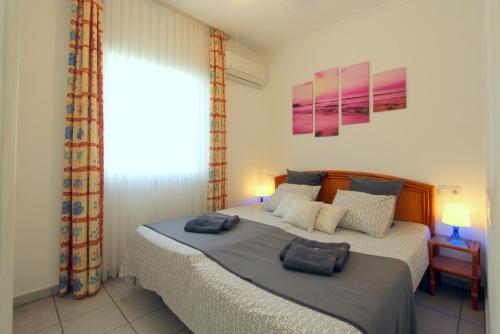 una camera da letto con un letto con due cuscini sopra di LEON INMO Apartment Denise - 10414 a Empuriabrava