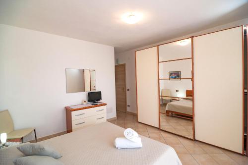a bedroom with a bed and a mirror at Le Dune in San Teodoro