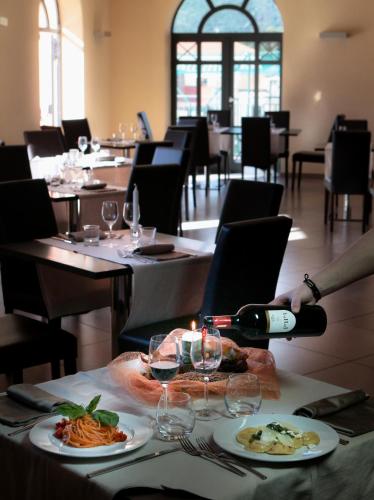 a person is pouring a glass of wine at a restaurant at San Severino Park Hotel & SPA, BW Signature Collection in Mercato San Severino