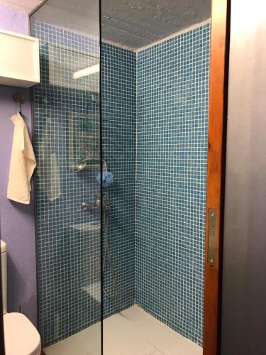bagno con doccia e pareti piastrellate di blu di Villa with swimming pool and tennis/basketball court a Theológos