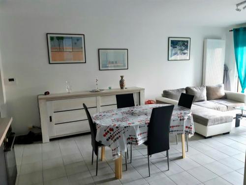 uma sala de estar com uma mesa e um sofá em Appartement à 150m de la grande plage de Sion em Saint-Hilaire-de-Riez