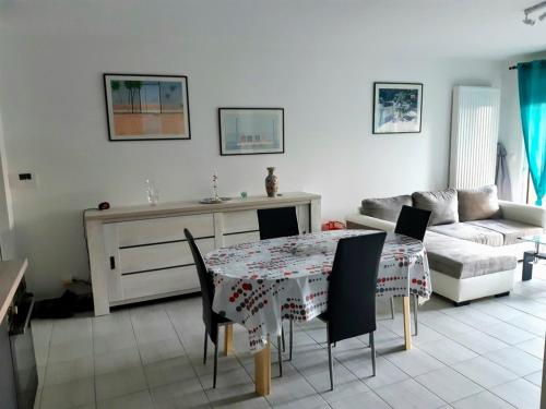 un salon avec une table et un canapé dans l'établissement Appartement à 150m de la grande plage de Sion, à Saint-Hilaire-de-Riez