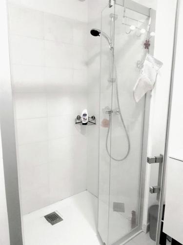 une douche avec une porte vitrée dans une salle de bain dans l'établissement Appartement à 150m de la grande plage de Sion, à Saint-Hilaire-de-Riez