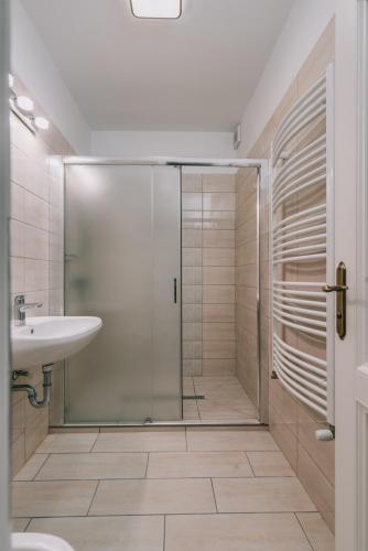 a bathroom with a glass shower and a sink at Bringa Villa in Balatonlelle