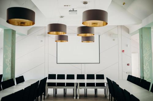 a dining room with black chairs and a white wall at Green Town in Vievis