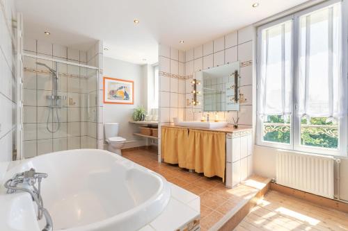 bagno con vasca e lavandino di Les Ormes - Grande maison avec Jacuzzi a Largny-sur-Automne