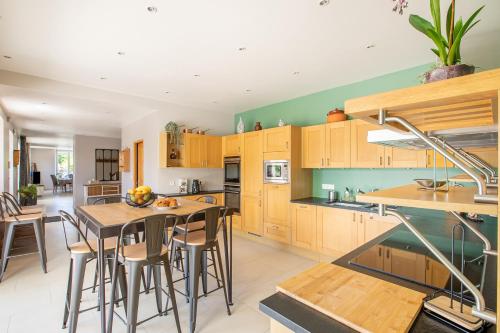 une cuisine avec des armoires en bois et une table et des chaises dans l'établissement Les Ormes - nature à 1h30 de Paris, à Largny-sur-Automne