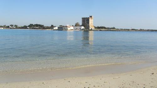 a view of the beach with a lighthouse in the distance at Porto Cesareo Sant'Isidoro Delizioso Trilo in Sant'Isidoro