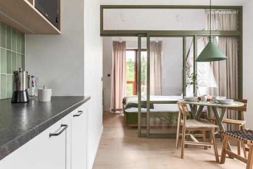 a kitchen with a table and a room with a bed at Tatra Resort & SPA in Kościelisko