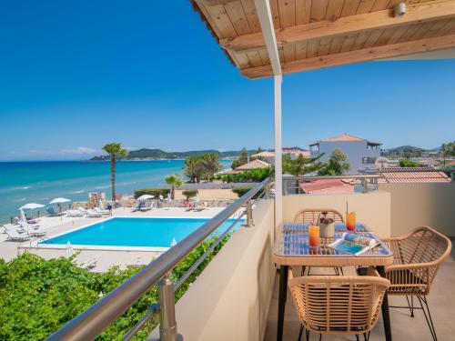 a balcony with a table and chairs and a view of the pool at Paradise Elegant Apartments - Perfect escape on the beach in Alykes