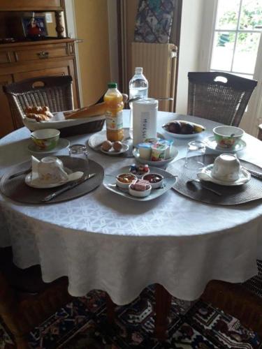 Chambre sympa belle propriété في Gouesnou: طاولة بيضاء عليها صحون طعام