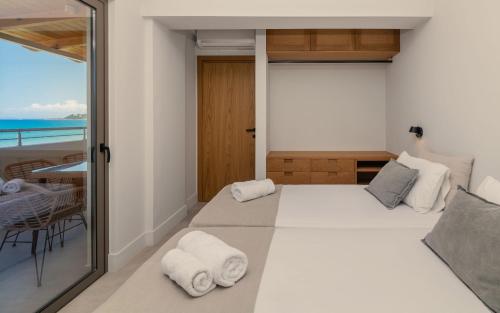 a bedroom with a bed with a view of the ocean at Paradise Elegant Apartments - Perfect escape on the beach in Alykes