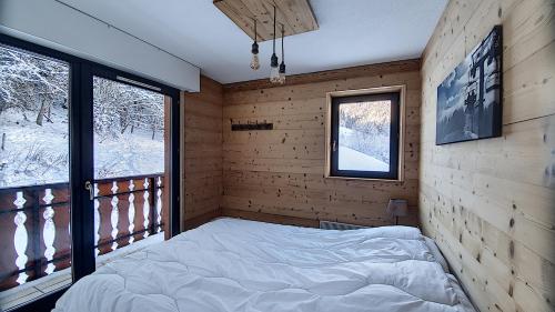 une chambre avec un lit sur un balcon dans l'établissement MAGNIFIQUE APPARTEMENT REFAIT à NEUF - CALME - 2 Chambres - 6 Personnes - Vue Montagne GRAND CERF 65, à Saint-Jean-dʼAulps