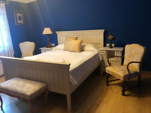 a bedroom with a bed and a desk and a chair at Casa Rural Carmenes in Ribaseca