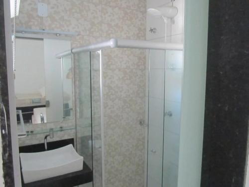 a bathroom with a glass shower and a sink at Apto 1 c piscina e wi-fi a 150 m da praia Mundaí in Porto Seguro