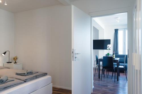 1 Schlafzimmer mit einem Bett und einem Esszimmer in der Unterkunft HITrental Wiedikon Apartments in Zürich