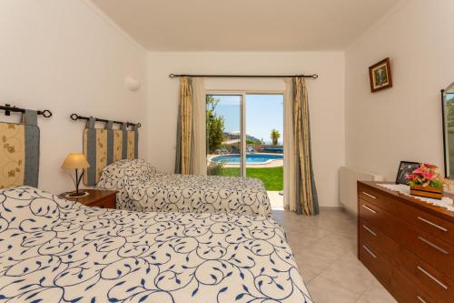 een slaapkamer met een bed en uitzicht op een zwembad bij Monte Lemos 29 in Luz