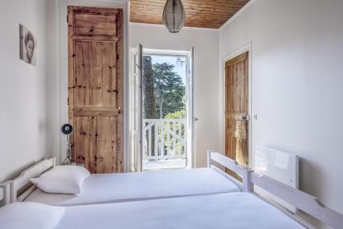 - une chambre avec 2 lits et une porte ouverte dans l'établissement CILAOS - Villa de charme les pieds dans l’eau, à Pornichet