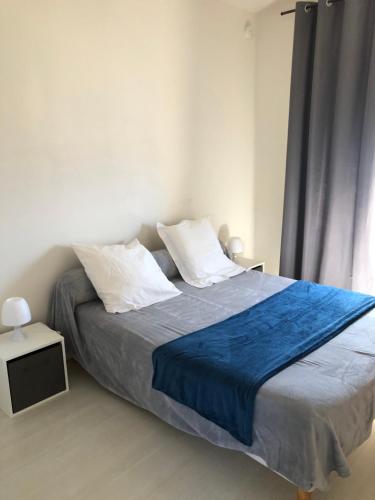 une chambre avec un grand lit avec une couverture bleue dans l'établissement Ajaccio centre ville cosy et spacieux avec climatisation, grande terrasse et vue mer, à Ajaccio