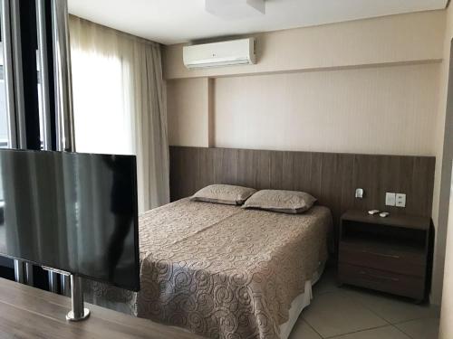 1 dormitorio con 1 cama y TV de pantalla plana en Apto à beira-mar com wi-fi e piscina em Fortaleza, en Fortaleza