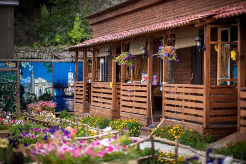 a house with flowers in front of it at Bilya Richky Hotel in Kamianets-Podilskyi