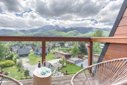 a balcony with two chairs and a view of mountains at Tatra Resort & SPA in Kościelisko