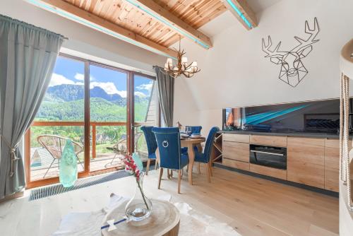 a living room with a table and a large window at Tatra Resort & SPA in Kościelisko