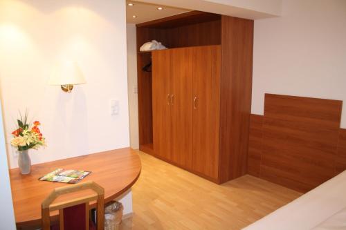 a room with a wooden table and a cabinet at Haus Hildegunde in Bad Füssing