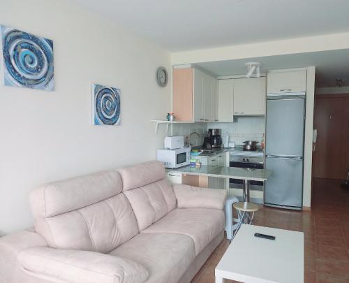 a living room with a couch and a kitchen at Apartamento Piscina Playa Cedeira in Cedeira