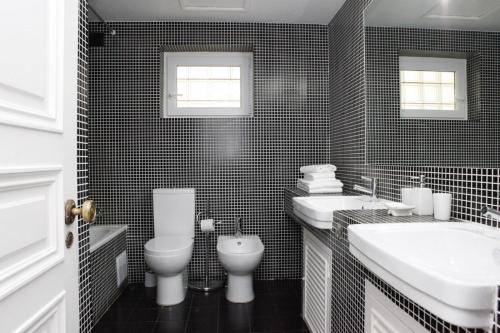 a black and white bathroom with two sinks and a toilet at Remarkable view over Cascais Bay in Cascais