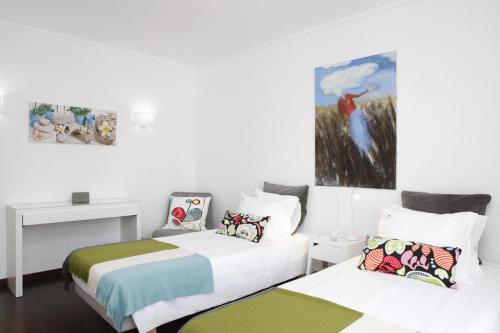 a room with two beds and a desk and a painting at Remarkable view over Cascais Bay in Cascais