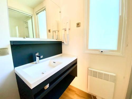 a bathroom with a sink and a mirror at See Breizh by Home From Home in Saint Malo