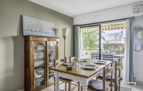 une salle à manger avec une table et des chaises et une fenêtre dans l'établissement Charmant appartement lumineux pour 4 au Pouliguen, au Pouliguen