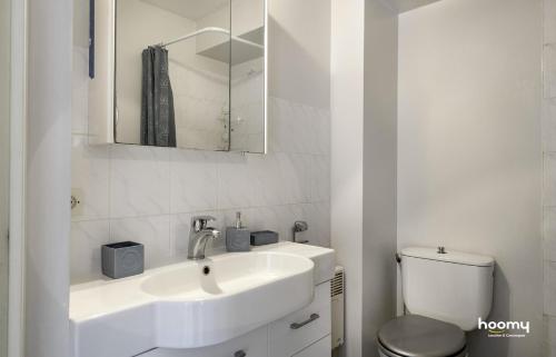 une salle de bain blanche avec un lavabo et des toilettes dans l'établissement Charmant appartement lumineux pour 4 au Pouliguen, au Pouliguen
