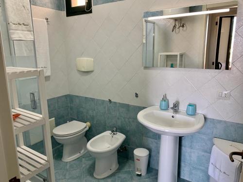 W łazience znajduje się umywalka, toaleta i lustro. w obiekcie Panoramic by Casa Vacanze Dei Bacini w mieście Porto Cesareo