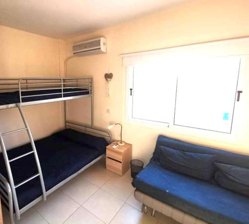 a small bedroom with a bunk bed and a window at Protaras Ionian Breeze House in Paralimni