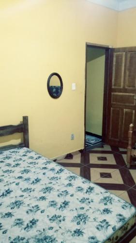 a bedroom with a bed and a clock on the wall at Casa Parada Modelo in Guapimirim