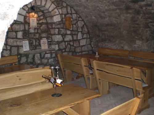 a restaurant with wooden tables and chairs in a stone building at Böne Vendégház és Borozó in Tokaj